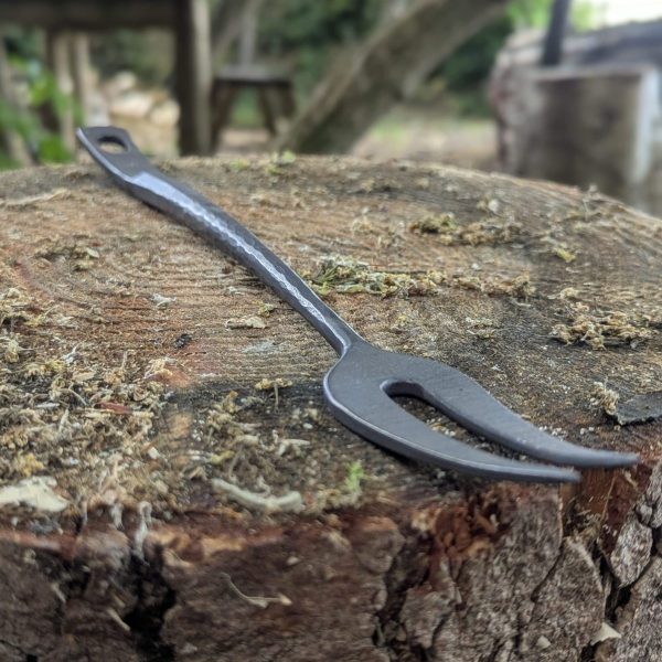Thorn wood forge bbq fork on a tree stump
