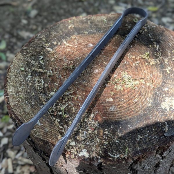 Thorn wood forge bbq tongs on a tree stump